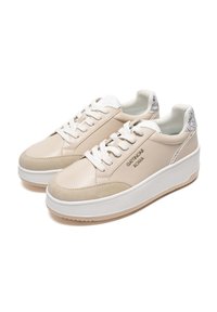 Beige läder- och mockaskor med vita snören, tjock vit sula och subtil logotypdetalj på sidan. Strukturerade detaljer vid hälen.