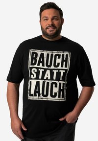 Černé bavlněné tričko s odvážným bílým nápisem "BAUCH STATT LAUCH" s opotřebovaným vzhledem, krátkým rukávem a volným střihem.