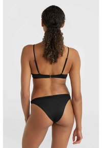 Svart bikiniöverdel med tunna justerbara remmar och knäppe baktill, ihopparad med högskurna svarta bikiniunderdelar. Slät tyg, minimalistisk design.