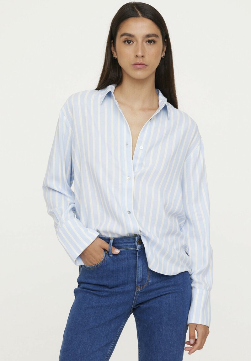 Light blue and white striped long-sleeve button-up shirt with a collar and single button closure. Paired with blue jeans.