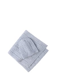 O pălărie tricotată de un albastru deschis și o pătură asortată, cu un model texturat în forma de hering. Material moale, aspect confortabil, formă dreptunghiulară a păturii.