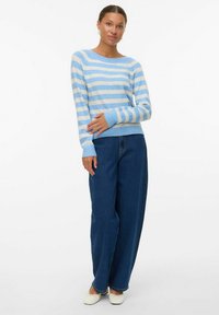 Lichtblauwe en witte gestreepte trui met een ronde halslijn, lange mouwen en geribbelde manchetten, gecombineerd met hoge, donkerblauwe jeans.