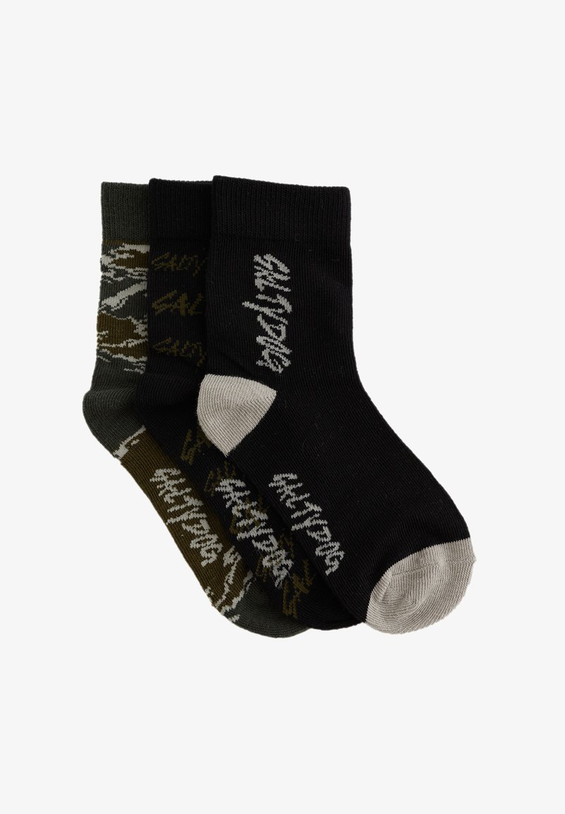 Tre par strumpor: ett par svarta med grå accenter, ett par mörkgröna med kamouflagemönster, och ett par olivgröna med ljusgröna texter, i bomullsblandning.