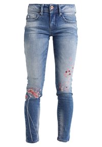 Skinny jeans in light blue denim, featuring distressed detailing and floral embroidery in pink on the left leg. Standard waistband with a button.
