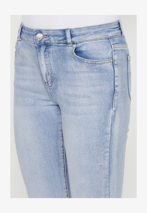 Jeans in denim azzurro chiaro con un design aderente, dotati di chiusura con bottone e zip frontale, cinque tasche e dettagli di sfumatura leggera.