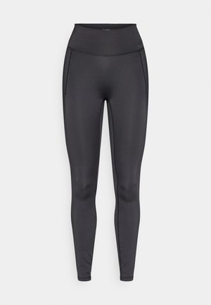 Musta korkeavyötäröiset leggingsit, joissa sileä ja joustava materiaali. Varustettu sivutaskuilla ja litteillä saumoilla mukavuutta ja joustavuutta varten.