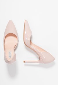 Lesklé světle růžové lodičky s jemným špičatým nosem a stiletto podpatky, zobrazené z vrchu a z boku na bílém pozadí.