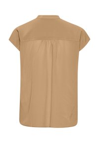 Kortärmad, beige blus som är tillverkad av ett mjukt tyg; har en mjuk krage och plisserad rygg. Sömmen är något rundad, vilket ger en avslappnad passform.