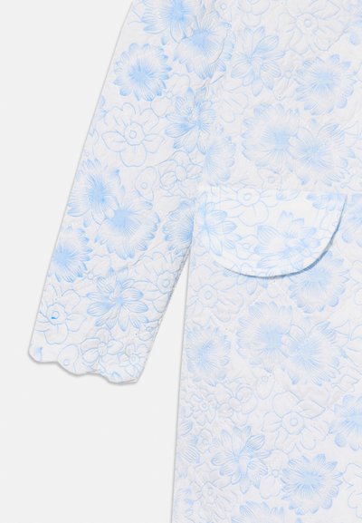 Quilted jacket featuring a white fabric with a light blue floral pattern. Includes a curved pocket and scalloped sleeve edges.