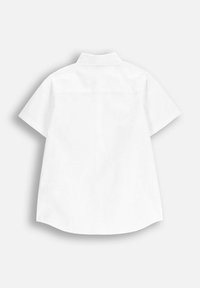 Biała koszula z krótkim rękawem, szpiczastym kołnierzykiem, prostym dołem i detalem na karczku z tyłu. Gładka faktura, prosty wzór, bez wzorów i ozdób.