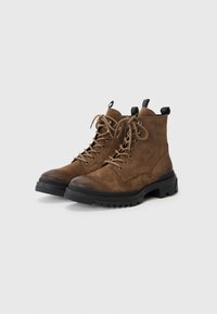 Brown suede ankle boots with a rugged black sole, featuring round toes, metal eyelets, and laces. Pull tab on the heel for easy wear.