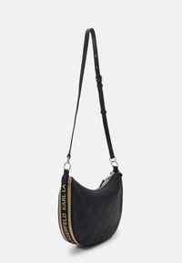 Borsa a spalla nera realizzata in pelle testurizzata. Caratterizzata da una silhouette curva, chiusura con zip e una tracolla beige con dettagli del logo.