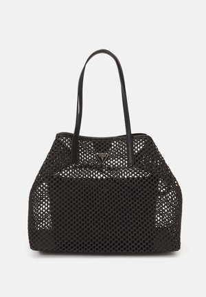 Black mesh tote bag with solid inner pouch, leather handles, and small triangular Guess logo on front.