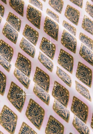 Tissu à motifs avec des motifs floraux dorés et bleus sur un fond rose, avec une texture lisse et des éléments de design en forme de losange.