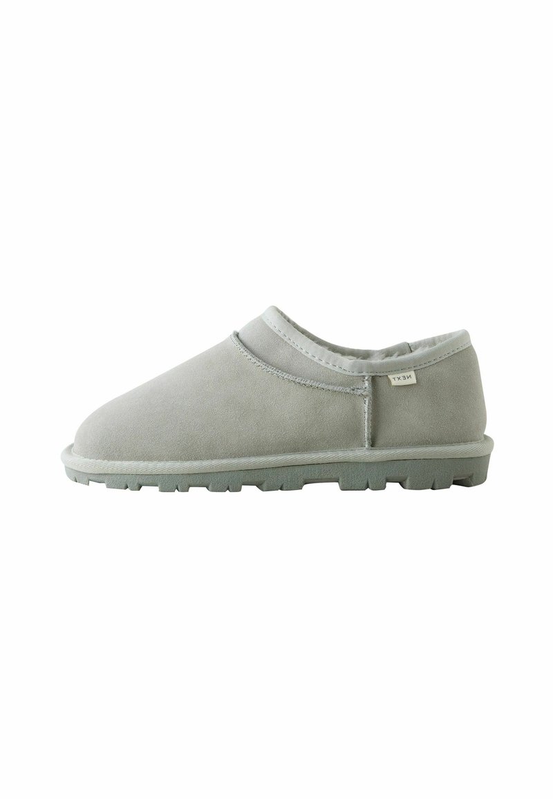 Grå ruskinds slip-on sko med rund tå, struktureret overdel, minimal syning og en gummisål med skridmønstre.