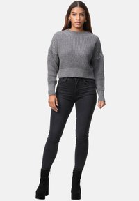 Grå, texturerad kortärmad tröja med stickad halsringning och muddar, parat med högmidjade svarta jeans och svarta klackiga ankelstövlar.