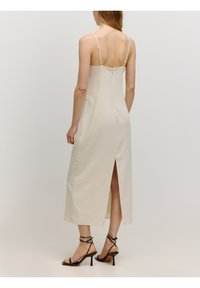 Beiges, ärmelloses Midi-Kleid mit geradem Schnitt und Rückenschlitz, ausgestattet mit verstellbaren Trägern und einem verdeckten Reißverschluss hinten.