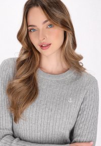 Grauer gerippter Pullover mit Rundhalsausschnitt. Verfügt über ein kleines weißes Ankerlogo auf der linken Seite. Weicher Stoff, taillierte Passform.