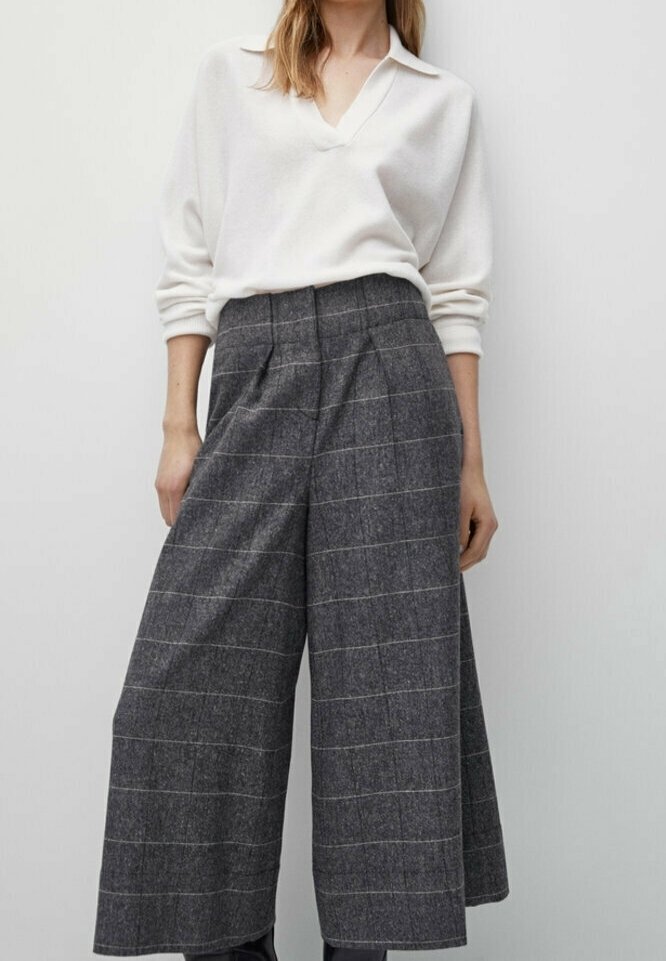 Pull blanc à manches longues avec col et pantalon large à carreaux gris. Le pantalon présente des lignes verticales et une texture de tissu douce.