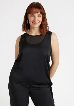Haut sans manches noir avec impression transparente au niveau du col. Tissu doux et lisse avec une coupe ample. Associé à un pantalon noir avec des liens latéraux.