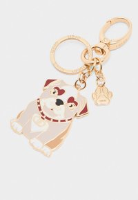Portachiavi color oro con una figura di cane con accenti beige, bianchi e marroni. Include un piccolo charm a forma di zampa e un anello circolare con il marchio.