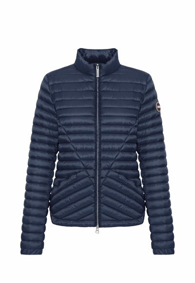 Navy blue quilted jacket with full front zipper, high collar, side pockets, and logo patch on left sleeve.