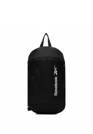 Zaino a tracolla nero Reebok con logo bianco verticale, scomparto principale con cerniera e anello superiore per il trasporto su sfondo bianco.
