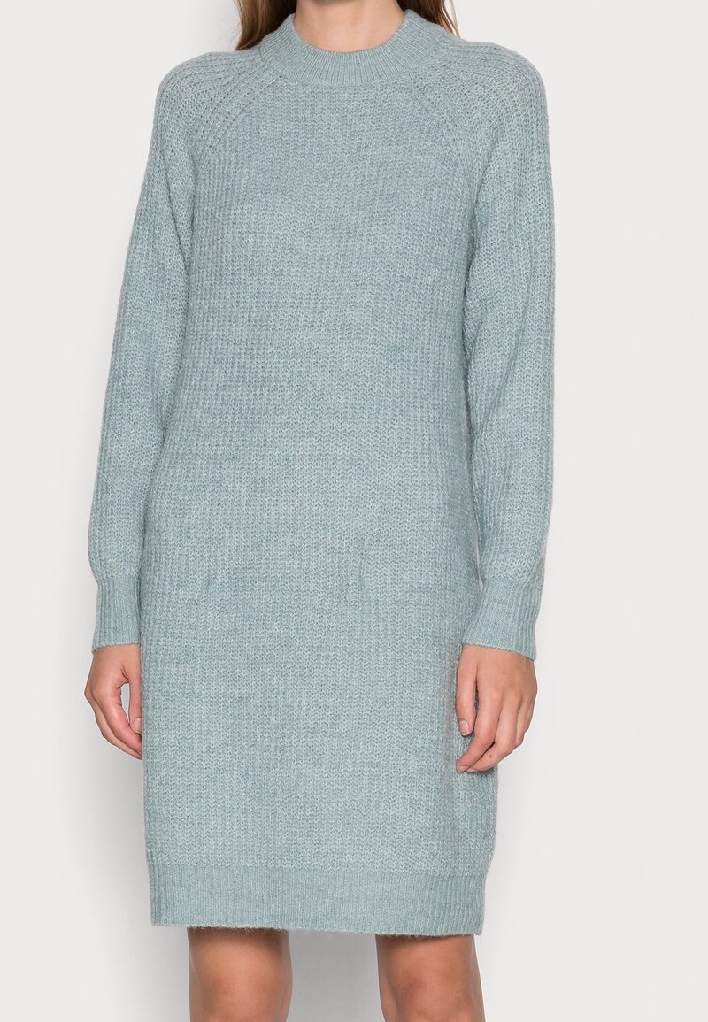 Abito a maniche lunghe in maglia azzurro chiaro, caratterizzato da un colletto a costine, una trama testurizzata e una linea dritta che arriva sopra il ginocchio.