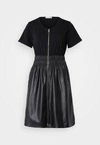 Schwarzes Kleid mit einem taillierten Oberteil und kurzen Ärmeln, Reißverschluss vorne und elastischem Bund, das in einen ausgestellten Rock aus Kunstleder übergeht.