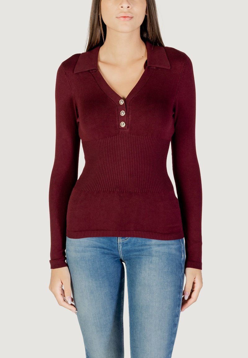 Top a maniche lunghe borgogna con scollatura a V e patta con tre bottoni, caratterizzato da una texture a coste e un design aderente, abbinato a jeans blu.