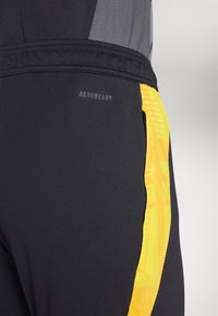 adidas Performance JAMAICA JFF TRAINING PANT - Leggings - black/semi solar gold