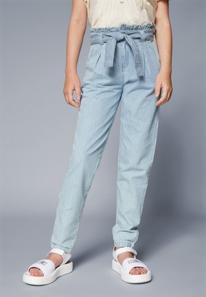 Lichtblauwe gestreepte broek met een elastische tailleband en decoratieve strik. Gecombineerd met witte platform sandalen met tekst.