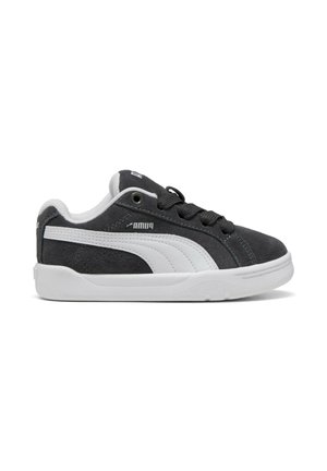 Scarpa da ginnastica Puma bianca e nera con tomaia in suede, striscia laterale bianca, lacci neri e suola in gomma bianca vista dal lato esterno.