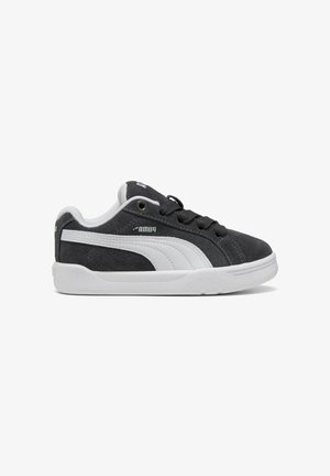 Scarpa da ginnastica Puma bianca e nera con tomaia in suede, striscia laterale bianca, lacci neri e suola in gomma bianca vista dal lato esterno.