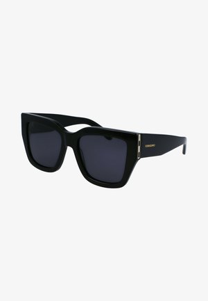 Černé oversized sluneční brýle s odvážným geometrickým tvarem, tmavými skly a zlatým logem jako akcentem na bočním pantu. Lesklý plastový rám.