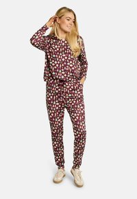 Ljubkov komplet za sproščanje z dolgimi rokavi in elastičnim pasom, okrašen s pisanimi okraski in vzorci, kombiniran z lahkimi supergami.