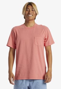 Růžové tričko z bavlny s kr�átkým rukávem, nabízející kulatý výstřih a náprsní kapsu. Materiál působí hladce a má volný střih.