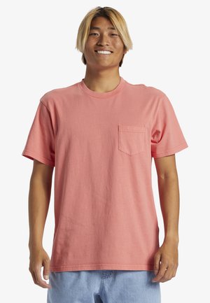 Korte mouwen roze katoenen T-shirt met een ronde hals en een borstzak. De stof lijkt soepel met een relaxte pasvorm.