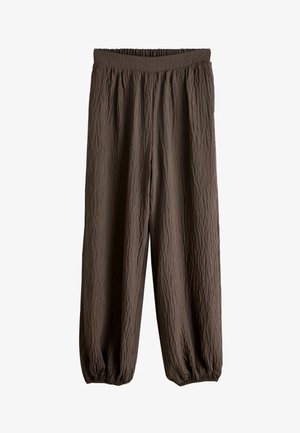 Bruna, texturerade byxor med resår i midjan och upptagna muddar. Mjukt, lätt tyg med skrynklig yta.