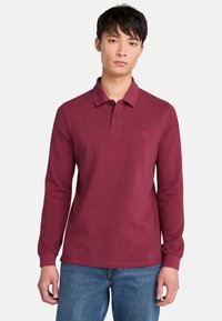 Bordový polo triko s dlouhým rukávem a l�ímečkem, dvouknoflíkovou légou a vyšívaným logem na hrudi. Bavlněná tkanina s hladkou texturou.