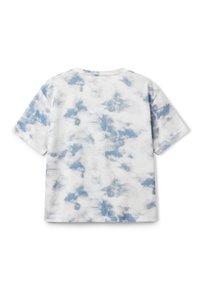 Bílý tričko s modrým tie-dye vzorem. Krátké rukávy a kulatý výstřih. Měkká tkanina s mírně volnějším střihem. Žádné viditelné kovové prvky ani detaily.
