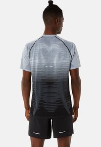 Short-sleeve athletic shirt featuring a gradient design, light blue and black colors, textured fabric, and contrast stitching details.