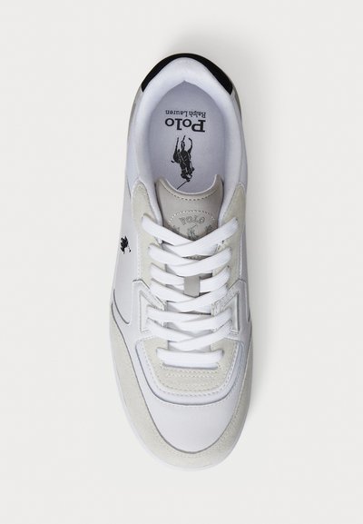 White athletic sneaker with suede and leather textures. Features white laces, a black heel, and a logo at the tongue and side.