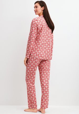 Ensemble de pyjama à motifs floraux rouges et blancs comprenant une chemise à manches longues et un pantalon assorti, confectionné dans un tissu léger avec une coupe décontractée.