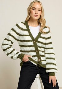 Cardigan tricoté avec des rayures vertes et blanches, col en V et trois boutons. Tissu texturé avec des poignets et un ourlet côtelés.