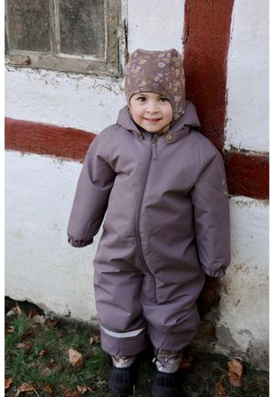 Lila vattentät overall med dragkedja och huva, utrustad med elastiska muddar och reflexränder; kombinerad med en matchande mönstrad hatt.