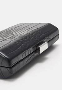 Clutch nera in pelle con effetto coccodrillo, dalla superficie liscia, forma rettangolare e dettagli della chiusura rettangolare in argento.