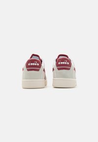 Hvite og burgunder sneakers med overdel i skinn, gummisåle og brodert logo på hælen. Utformet med hvit tå og burgunder detaljer.