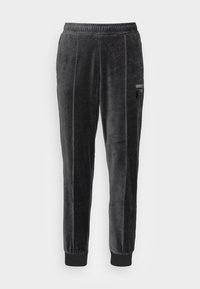 Svarta sammetssoffor med dragsko i midjan, avsmalnande ben, sidofickor och ribbade muddar. Har vertikala sömdetaljer.