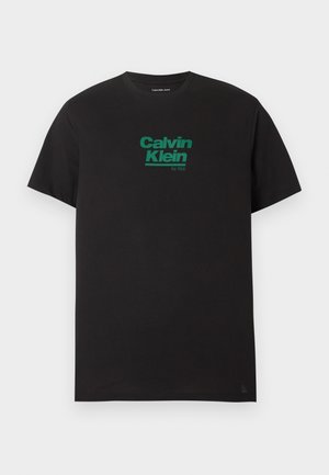 Czarny T-shirt z krótkim rękawem i okrągłym dekoltem, z zielonym logo "Calvin Klein Est. 1968" umieszczonym na środku klatki piersiowej na jednolitym tle.